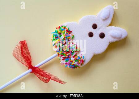 Coniglietto di pasqua marshmallow lollipop sul pallido sfondo giallo Foto Stock