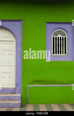 Verde e viola muro di pietra della casa coloniale con legno bianco porta chiusa in Granada Foto Stock