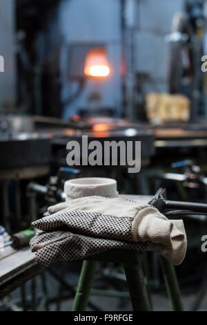 Guanti di protezione su un banco di lavoro ad una soffiatura del vetro Fabbricazione / forno per vetro Foto Stock