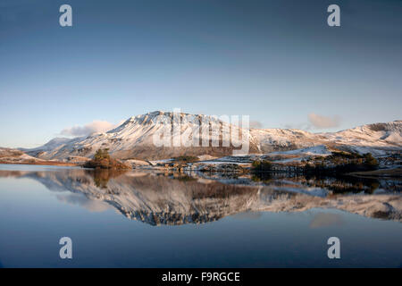 D'inverno la neve pendii coperti di cader Idris mountain range si riflettono nell'acqua ancora di Cregennen laghi. Foto Stock