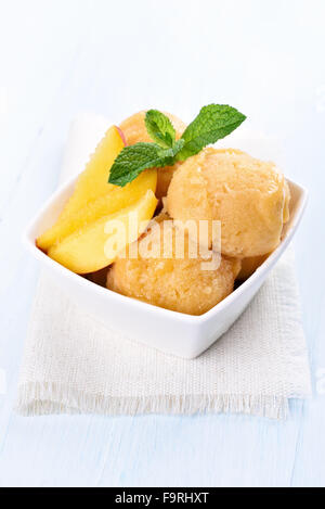 Pesca di frutta gelato con fette nella ciotola bianco Foto Stock