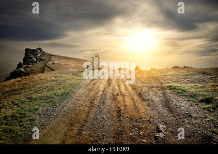 Stony road nelle montagne al tramonto Foto Stock