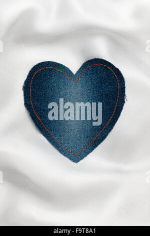Cuore realizzato in tessuto denim con cuciture gialle su bianco seta, con spazio per il testo Foto Stock