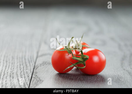 Mature i pomodorini sulla tavola di legno Foto Stock