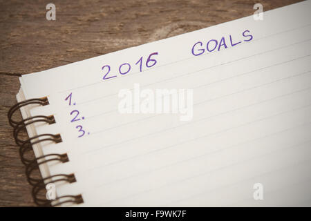 Notebook con gli obiettivi dell'anno 2016 su sfondo di legno. Selictive focus Foto Stock