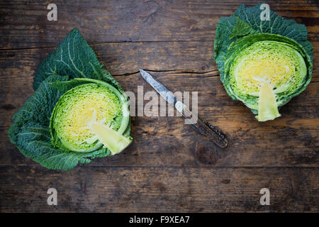 Savoy e il coltello su legno, tagliati a metà Foto Stock