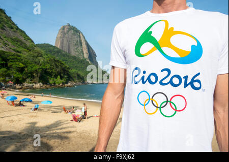 RIO DE JANEIRO, Brasile - 10 novembre 2015: uomo che indossa gazzetta Rio 2016 Giochi Olimpici t-shirt si erge di fronte Sugarloaf Mt. Foto Stock