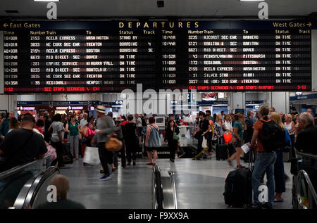 Le persone all'interno di Penn Station con informazioni sulla partenza schermo in background.Manhattan,New York City,USA Foto Stock