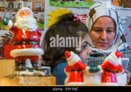 Schwerin, Germania. Xiv Dic, 2015. Cinque-anno-vecchio Nisren dalla Siria e sua madre Abir Kroma partecipare alla festa di Natale per le famiglie di rifugiati e il tedesco vicini nei genitori' cafe del bambino tedesco Tutela League a Schwerin, Germania, 14 dicembre 2015. L'incontro settimanale per le famiglie di rifugiati e residenti di Schwerin appartamento complesso di blocco ha avuto luogo dal mese di ottobre. Oltre a fornire uno spazio per le persone di incontrarsi, il meeting offre anche la possibilità di imparare la lingua tedesca e un luogo per aiutare a chiarire i problemi quotidiani. Foto: Jens BUETTNER/dpa/Alamy Live News Foto Stock