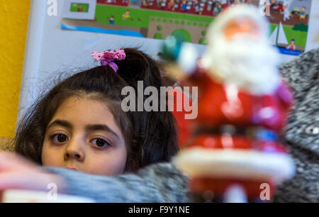 Schwerin, Germania. Xiv Dic, 2015. Cinque-anno-vecchio Nisren dalla Siria assiste la festa di Natale per le famiglie di rifugiati e il tedesco vicini nei genitori' cafe del bambino tedesco Tutela League a Schwerin, Germania, 14 dicembre 2015. L'incontro settimanale per le famiglie di rifugiati e residenti di Schwerin appartamento complesso di blocco ha avuto luogo dal mese di ottobre. Oltre a fornire uno spazio per le persone di incontrarsi, il meeting offre anche la possibilità di imparare la lingua tedesca e un luogo per aiutare a chiarire i problemi quotidiani. Foto: Jens BUETTNER/dpa/Alamy Live News Foto Stock