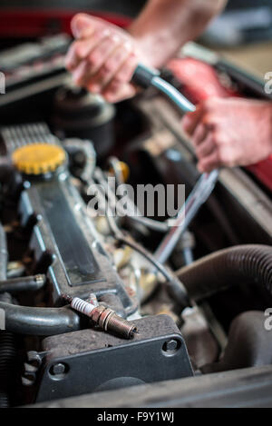 A partire candela di accensione meccanico di automobili in automatico il servizio di riparazione Foto Stock