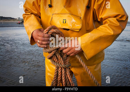 Dettaglio del pescatore con le mani la corda. La pesca dei gamberetti - Il mondo della ultima rimanendo a cavallo dei pescatori. Oostduinkerke, Belgio. Foto Stock