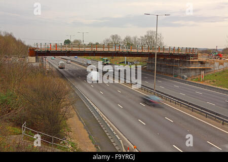 Un nuovo ponte autostradale in costruzione con le principali span al posto sul cemento tralicci su entrambi i lati e ringhiere temporanea. Foto Stock