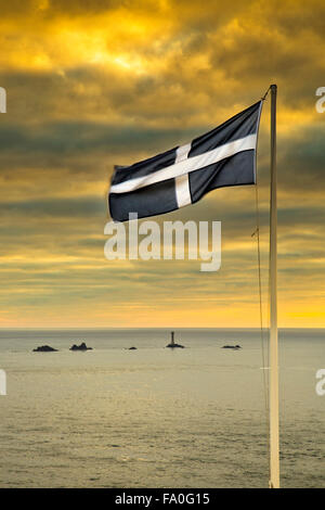 Land's End; St Piran bandiera; cercando di Longships Lighthouse; Cornovaglia; Regno Unito Foto Stock