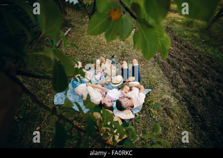 La famiglia felice sul prato nel parco Foto Stock