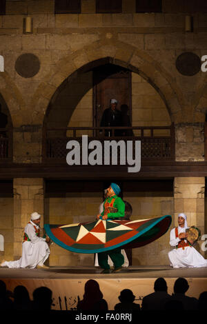 Un ballerino di danza sufi in verde la filatura suo abito durante un derviscio armato delle prestazioni, una famosa attrazione turistica, Al Ghouri Foto Stock