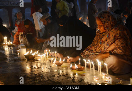 Lahore, Pakistan. Xix Dec, 2015. Musulmano pakistano devoti accendono le candele e lampade in terracotta presso il santuario del famoso quindicesimo secolo Santo Sufi Hazrat Mir Mohammed Muayyinul. Migliaia di persone di tutto il paese visitare il santuario per rendere omaggio a lui durante la tre giorni di festival.Il santo era altrettanto popolare tra i musulmani e sikh, le religioni come Mian Mir è andato ad Amritsar (India) nel dicembre 1588 a gettare le fondamenta per i sikh santissimo sito, il Tempio d'oro, che è comunemente noto come Sri Harminder Sahib. © Rana Sajid Hussain/Pacific Press/Alamy Live News Foto Stock