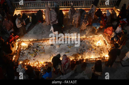 Lahore, Pakistan. Xix Dec, 2015. Musulmano pakistano devoti accendono le candele e lampade in terracotta presso il santuario del famoso quindicesimo secolo Santo Sufi Hazrat Mir Mohammed Muayyinul. Migliaia di persone di tutto il paese visitare il santuario per rendere omaggio a lui durante la tre giorni di festival.Il santo era altrettanto popolare tra i musulmani e sikh, le religioni come Mian Mir è andato ad Amritsar (India) nel dicembre 1588 a gettare le fondamenta per i sikh santissimo sito, il Tempio d'oro, che è comunemente noto come Sri Harminder Sahib. © Rana Sajid Hussain/Pacific Press/Alamy Live News Foto Stock