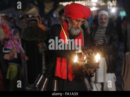 Lahore, Pakistan. Xix Dec, 2015. Musulmana Pakistana luci devoto candele e lampade in terracotta presso il santuario del famoso quindicesimo secolo Santo Sufi Hazrat Mir Mohammed Muayyinul. Migliaia di persone di tutto il paese visitare il santuario per rendere omaggio a lui durante la tre giorni di festival.Il santo era altrettanto popolare tra i musulmani e sikh, le religioni come Mian Mir è andato ad Amritsar (India) nel dicembre 1588 a gettare le fondamenta per i sikh santissimo sito, il Tempio d'oro, che è comunemente noto come Sri Harminder Sahib. © Rana Sajid Hussain/Pacific Press/Alamy Live News Foto Stock