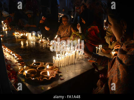 Lahore, Pakistan. Xix Dec, 2015. Musulmano pakistano devoti accendono le candele e lampade in terracotta presso il santuario del famoso quindicesimo secolo Santo Sufi Hazrat Mir Mohammed Muayyinul. Migliaia di persone di tutto il paese visitare il santuario per rendere omaggio a lui durante la tre giorni di festival.Il santo era altrettanto popolare tra i musulmani e sikh, le religioni come Mian Mir è andato ad Amritsar (India) nel dicembre 1588 a gettare le fondamenta per i sikh santissimo sito, il Tempio d'oro, che è comunemente noto come Sri Harminder Sahib. © Rana Sajid Hussain/Pacific Press/Alamy Live News Foto Stock