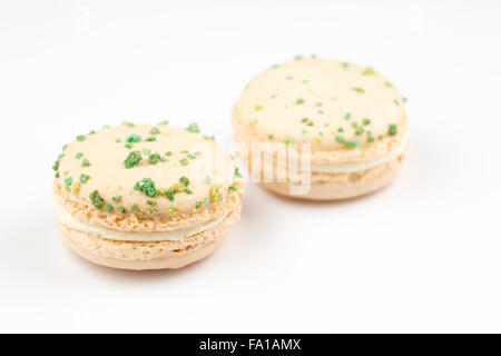 Macaron verdi e bianchi, sapore di vaniglia e basilico, su fondo bianco Foto Stock