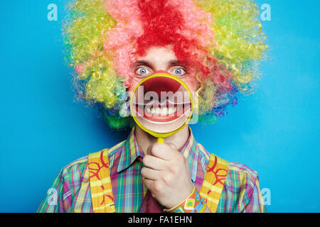 Ritratto allegro clown con il grande sorriso su uno sfondo blu Foto Stock