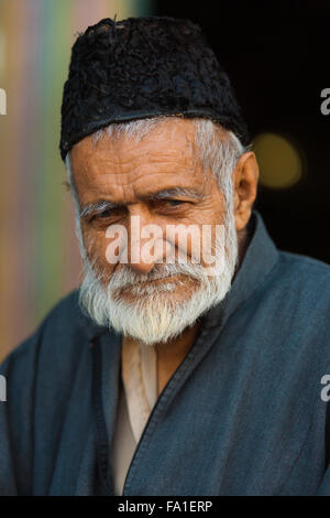 Ritratto di senior maturo musulmano del Kashmir uomo con barba grigia, black hat lasciando lo Shah-E-Hamdan moschea Foto Stock