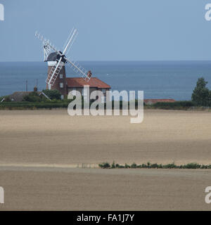 Vecchio Mulino a Vento accanto ad un campo di grano, Weybourne, Norfolk, Inghilterra, Regno Unito. Foto Stock