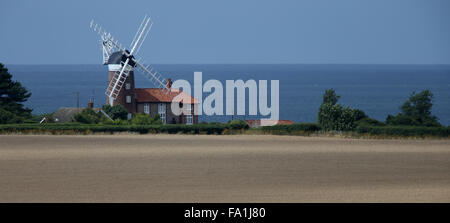 Vecchio Mulino a Vento accanto ad un campo di grano, Weybourne, Norfolk, Inghilterra, Regno Unito. Foto Stock