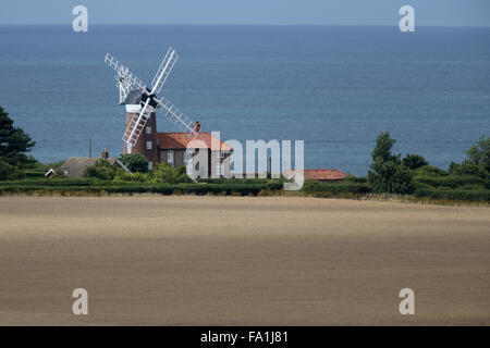 Vecchio Mulino a Vento accanto ad un campo di grano, Weybourne, Norfolk, Inghilterra, Regno Unito. Foto Stock