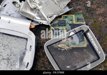 Una pila di pezzi rotti di telefoni cellulari e batterie del telefono Foto Stock