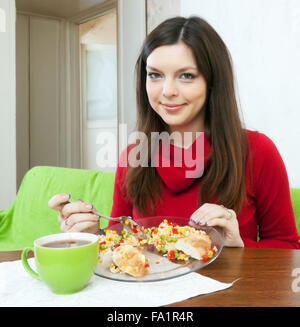 Brunette girl diviso il pranzo per due parti a mangiare di meno Foto Stock