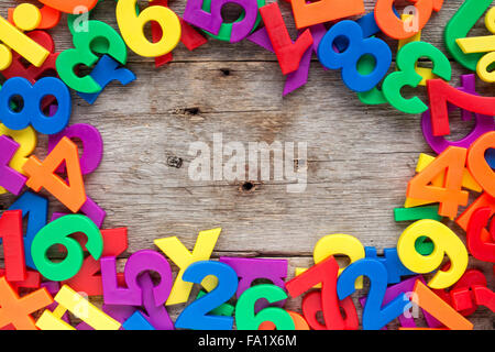 Bordo superiore del giocattolo colorato magnetico di lettere e numeri su un sfondo di legno Foto Stock
