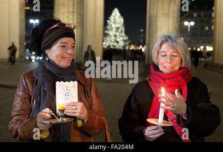 Berlino, Germania. Xix Dec, 2015. Due partecipanti nella catena di luci in piedi presso la Porta di Brandeburgo a Berlino, Germania, 19 dicembre 2015. Un uomo dal Baden-Wuerttemberg chiamato per il 'Lichterkette Muenchen - Berlino' (lit. La catena di luci Monaco di Baviera - Berlino) iniziativa, per inviare una pre-natale messaggio di pace e di amore. Foto: JOERG CARSTENSEN/DPA/Alamy Live News Foto Stock