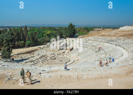 Turisti in Sicilia turismo, vista di turisti di esplorare l'antico teatro greco nel parco archeologico di Siracusa (Siracusa) Sicilia. Foto Stock