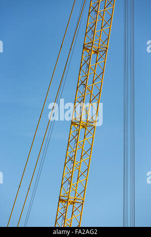 Dettaglio yellow crane jib contro un cielo blu Foto Stock