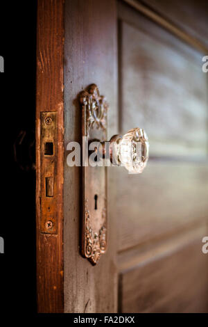 Una vecchia porta in legno con un antico pomello in vetro. Foto Stock