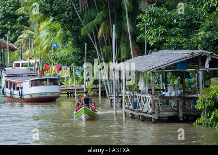 Una barca tradizionale e casa sul fiume su un torrente in Amazzonia brasiliana Foto Stock