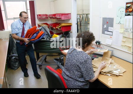 Operativa Logistica di scarico rimorchiatore postali e di posta esterno essendo elaborati da commesso in ospedale post camera, Foto Stock