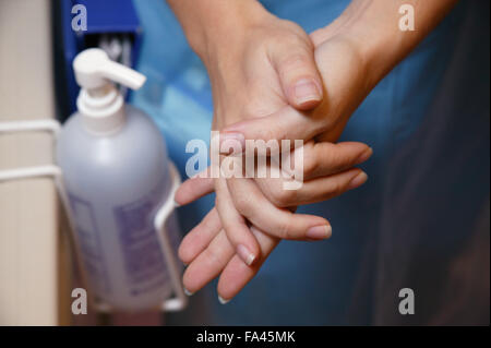 Il personale infermiere utilizzando handrub alla fine del letto di pazienti per ridurre al minimo le infezioni crociate, Foto Stock