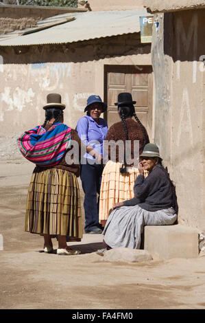 Le donne in Aymara tradizionale abbigliamento e Bowler Hats chat su angolo di strada in Luribay, Bolivia, Sud America Foto Stock