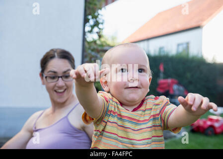 La madre è stupito circa il suo bambino figlio sui primi passi, Monaco di Baviera, Germania Foto Stock