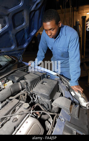 Mechanic guardando nel cofano del motore di un'auto, Foto Stock