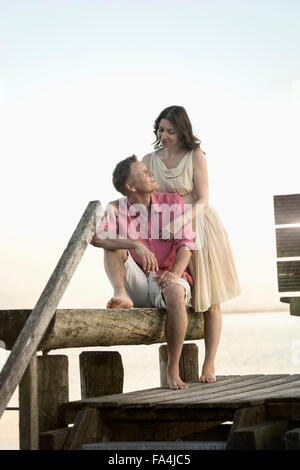 Coppia matura guardando ogni altro e sorridente sul molo, Baviera, Germania Foto Stock