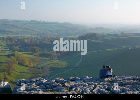 Giovane seduto in cima Malham Cove - Yorkshire Dales, England, Regno Unito Foto Stock