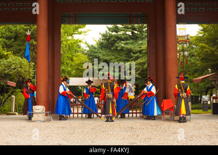 Soldati armati in tradizionale costume in piedi, rievoca la modifica delle protezioni in corrispondenza della porta di ingresso del Palazzo Deoksugung Foto Stock