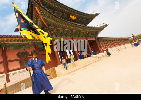 Un flag di guardia di antico costume blu pronto permanente presso il cancello di ingresso del palazzo Gyeongbokgung, la vecchia residenza reale Foto Stock