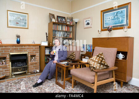 Donna anziana seduti a casa con una tazza di tè, Foto Stock