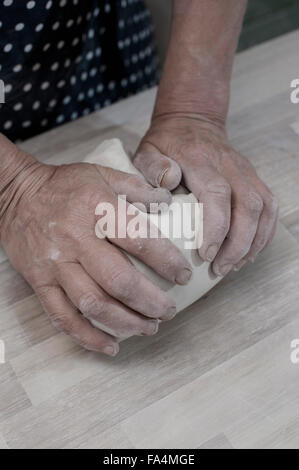 Close-up di potter femmina di argilla per impastare sul banco di lavoro, Baviera, Germania Foto Stock