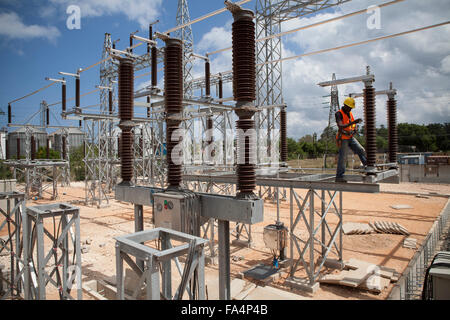 Un ingegnere elettrico gestisce apparecchiature a Mtoni stazione di servizio a Zanzibar, Tanzania Africa Orientale. Foto Stock